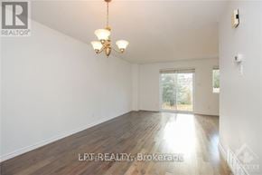 Ottawa apartment for rent - A room with wooden floors and a chandelier hanging from the ceiling.