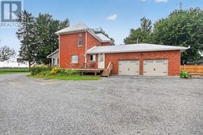 Ottawa apartment for rent - A red brick house with a grey roof and a gravel driveway.