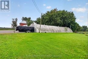 Ottawa apartment for rent - A large building with a grey roof is surrounded by a grassy field.