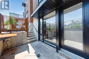 Ottawa apartment for rent - A modern house entrance with a glass door and a wooden railing.