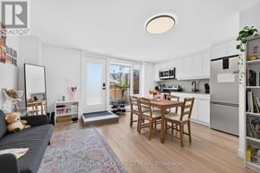Ottawa apartment for rent - A living room with a grey couch and a dining table with chairs.