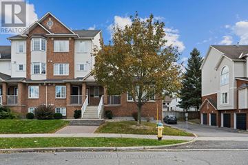 Ottawa townhouse for rent - A large brick apartment building with a tree in front of it.