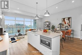 St. Catharines (Downtown) condo for rent - A modern kitchen with a large island and a view of the outdoors through the windows.