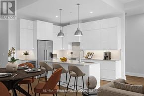St. Catharines (Downtown) condo for rent - A modern kitchen with a dining table set for two.