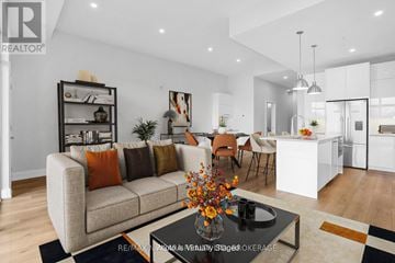 St. Catharines (Downtown) condo for rent - A modern living room with a grey sofa and a coffee table with a vase of flowers on it.