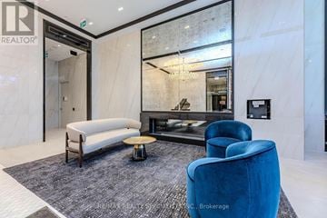 Toronto (Bay Street Corridor) condo for rent - A living room with a blue chair and a white sofa.