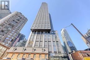 Toronto (Bay Street Corridor) condo for rent - A tall building with a curved top stands out among other buildings.