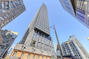 Toronto (Bay Street Corridor) condo for rent - A tall building with a glass facade stands in the center of a cityscape.
