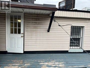 Toronto (North Riverdale) apartment for rent - A small house with a white door and a window with bars.