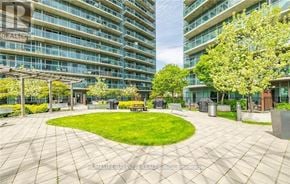 Toronto (Mimico) condo for rent - A large grassy area surrounded by buildings with a walkway around it.
