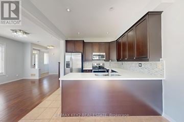 Pickering (Duffin Heights) apartment for rent - A modern kitchen with wooden cabinets and a stainless steel island.