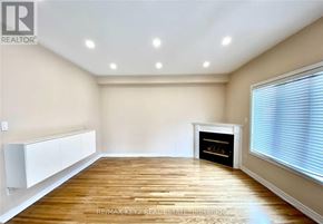 Richmond Hill (Langstaff) apartment for rent - A spacious room with a fireplace and wooden flooring.