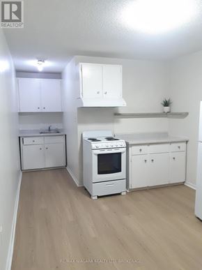 St. Catharines (Downtown) multi-family for rent - A room with wooden flooring and white walls.