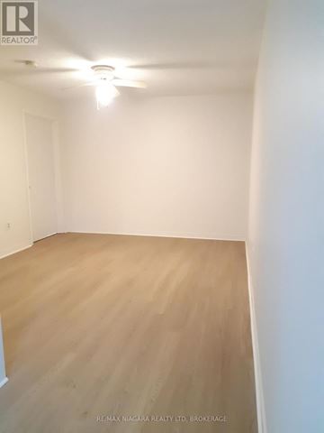 St. Catharines (Downtown) multi-family for rent - A white kitchen with wooden floors and white appliances.
