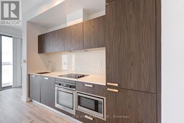 Toronto (Church-Yonge Corridor) condo for rent - A modern kitchen with wooden cabinets and stainless steel appliances.