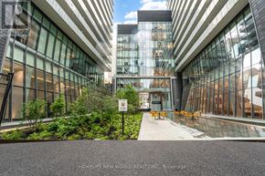 Toronto (Church-Yonge Corridor) condo for rent - A modern building with glass windows and a sign that says "HOMELIFE NEW WORLD REALTY INC."