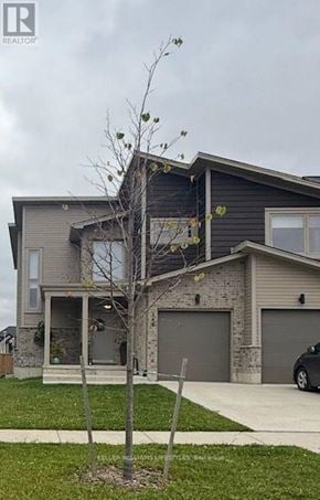 London East (East D) apartment for rent - A house with a grey garage door and a tree in front.