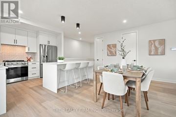 London South (South U) townhouse for rent - A modern kitchen with white cabinets and a dining table set for two.