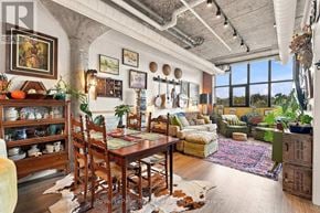 Guelph (St. Patrick's Ward) condo for rent - A dining room with a wooden table surrounded by chairs and a large window.