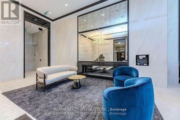 Toronto (Bay Street Corridor) condo for rent - A living room with a blue chair and a white sofa.
