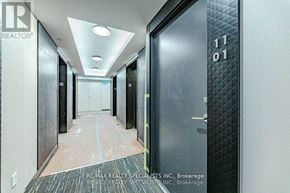 Toronto (Bay Street Corridor) condo for rent - A hallway with a black door on the right and a white door on the left with the number 1101 on the door.
