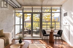Toronto (South Parkdale) condo for rent - A living room with a table and chairs in front of a large window.