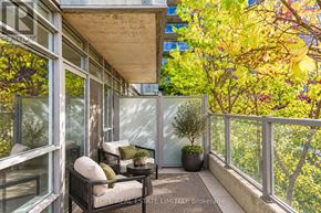 Toronto (South Parkdale) condo for rent - A balcony with a table and chairs is surrounded by green plants.
