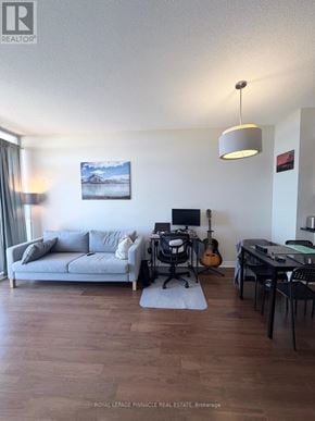 Oakville (Ro River Oaks) condo for rent - A living room with a grey couch, a television, a guitar, a chair, and a desk.