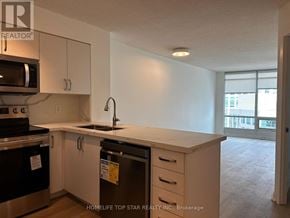 Toronto (Waterfront Communities) condo for rent - A kitchen with white cabinets and a black dishwasher.