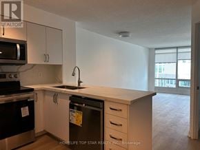 Toronto (Waterfront Communities) condo for rent - A kitchen with white cabinets and a black dishwasher.