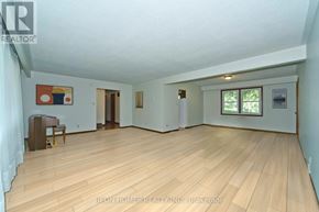 Markham (Box Grove) apartment for rent - A room with wooden flooring and white walls, with a painting on the wall and a wooden chair.