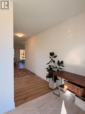 Loyalist (Odessa) apartment for rent - A room with a wooden floor and a white wall with a plant on the side table.