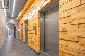 Toronto (Kensington-Chinatown) condo for rent - A hallway with wooden walls and a metal elevator door.