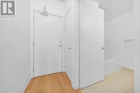 Toronto (Kensington-Chinatown) condo for rent - A white room with a door and a wooden floor.