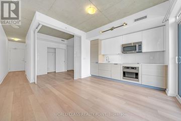Toronto (Kensington-Chinatown) condo for rent - A spacious kitchen with white cabinets and a microwave above the oven.