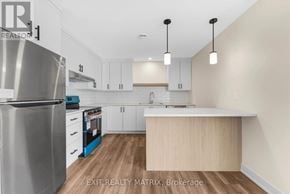 Russell multi-family for rent - A kitchen with a stainless steel refrigerator, white cabinets, and a wooden island.