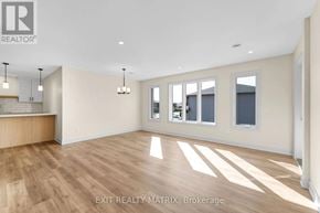 Russell multi-family for rent - A room with wooden floors and white walls, with a window and a door visible.