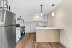 Russell multi-family for rent - A kitchen with a stainless steel refrigerator, white cabinets, and a wooden island.
