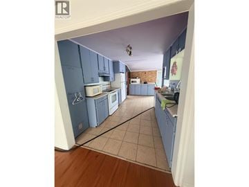 Maple Ridge apartment for rent - A kitchen with blue cabinets and a tiled floor.