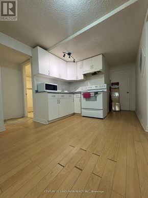 Richmond Hill (Harding) apartment for rent - A kitchen with white cabinets and a microwave.