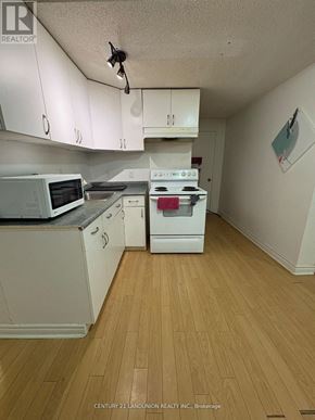 Richmond Hill (Harding) apartment for rent - A kitchen with white cabinets and a wood floor.