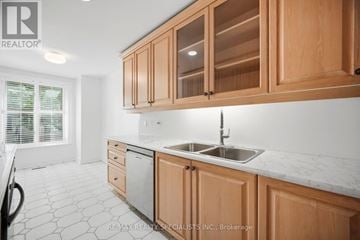 Toronto (Casa Loma) townhouse for rent - A kitchen with wooden cabinets and a marble countertop.