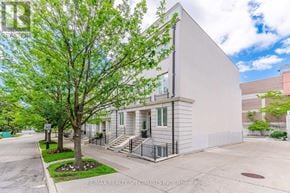Toronto (Casa Loma) townhouse for rent - A tree in front of a building with a sign that says RE/MAX Realty Specialists Inc. Brokerage.