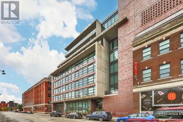 Toronto (South Riverdale) condo for rent - A modern building with a glass facade is the main focus of the image.