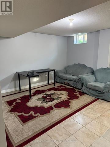 Brampton (Credit Valley) apartment for rent - A living room with a grey couch and a red rug.