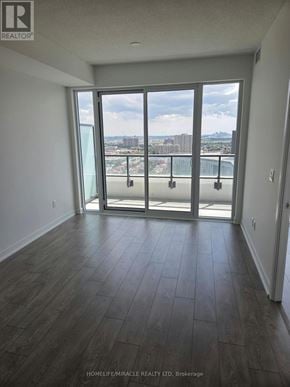 Brampton (Fletcher's Creek South) condo for rent - A room with a view of the city through a large window.