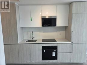 Brampton (Fletcher's Creek South) condo for rent - A kitchen with white cabinets and a black dishwasher.