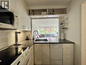 Vancouver apartment for rent - A kitchen with white cabinets and a black countertop.