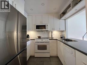 Vancouver apartment for rent - A modern kitchen with white cabinets and stainless steel appliances.