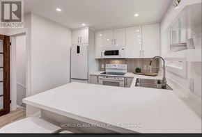 Toronto (Don Valley Village) apartment for rent - A modern kitchen with white appliances and cabinets.